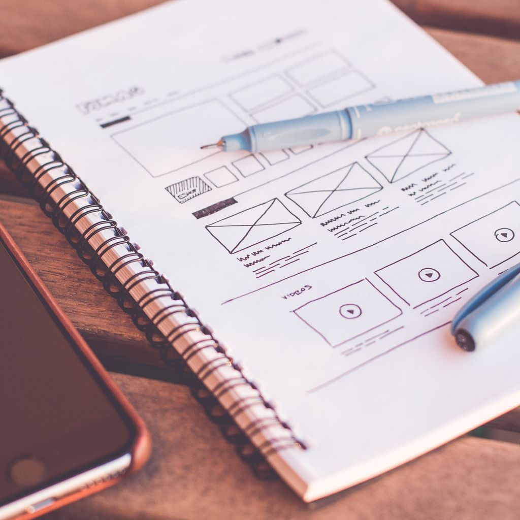 Wireframe sketches in a notebook on a desk