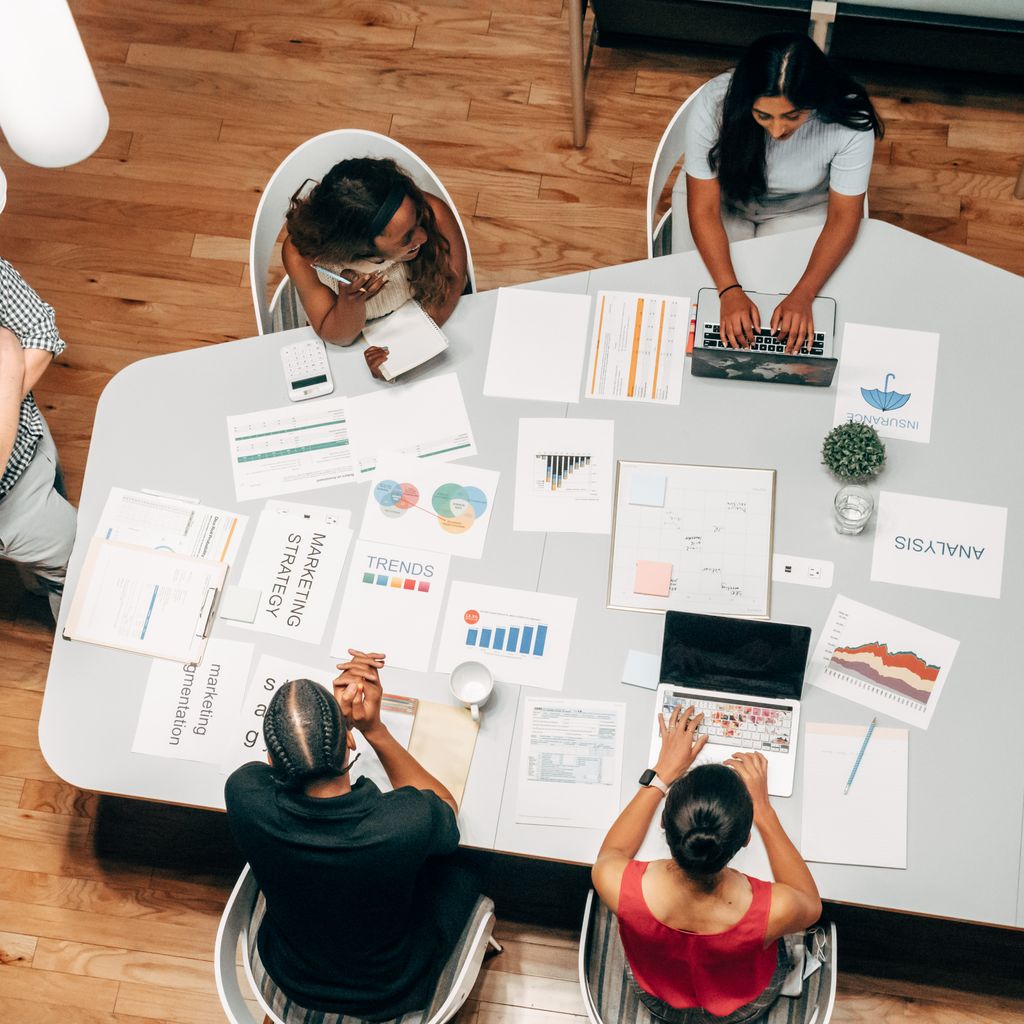 A marketing team reviewing campaign charts around a shared table