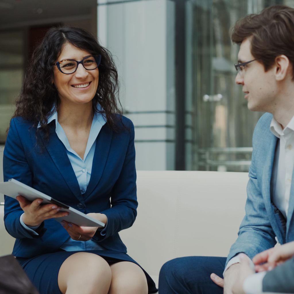 Consultant with a tablet advising a client in an office