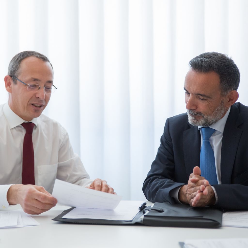 Two executives negotiating a contract at a meeting table
