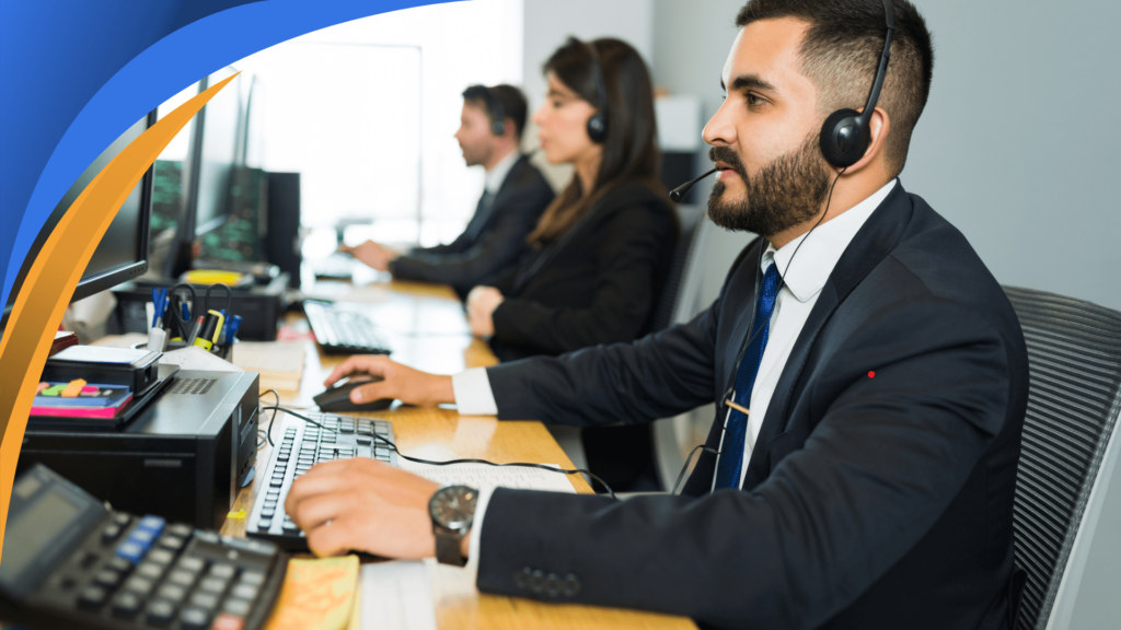 Sales representatives with headsets working at computers in an office