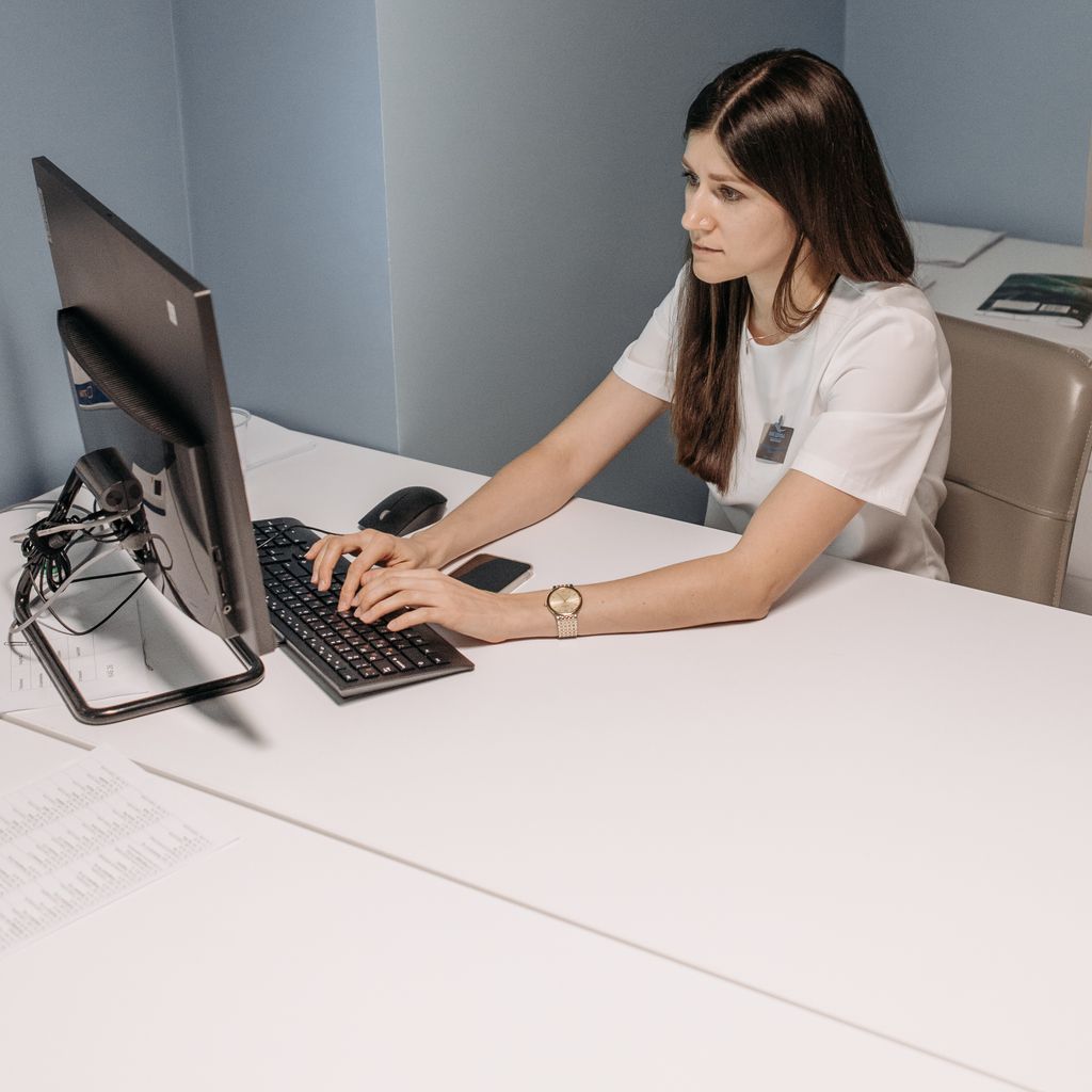 A woman working at a computer in a healthcare office