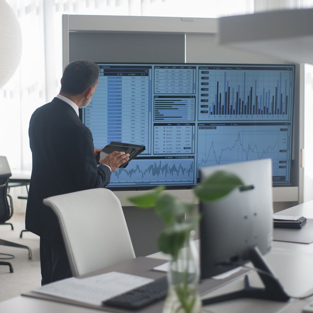 A financial analyst reviewing performance dashboards in an office