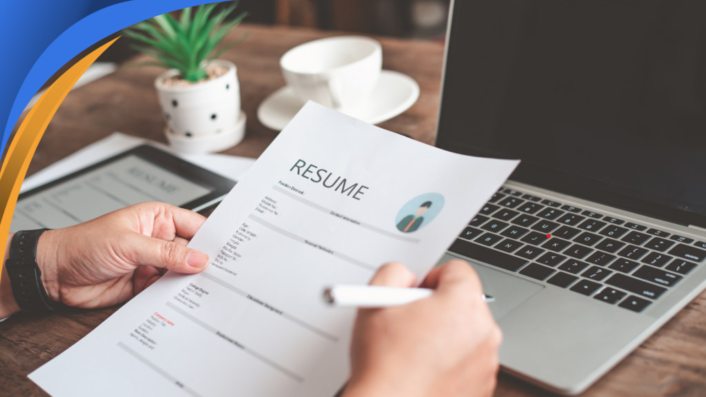Interviewer holding a printed resume next to a laptop before a remote interview