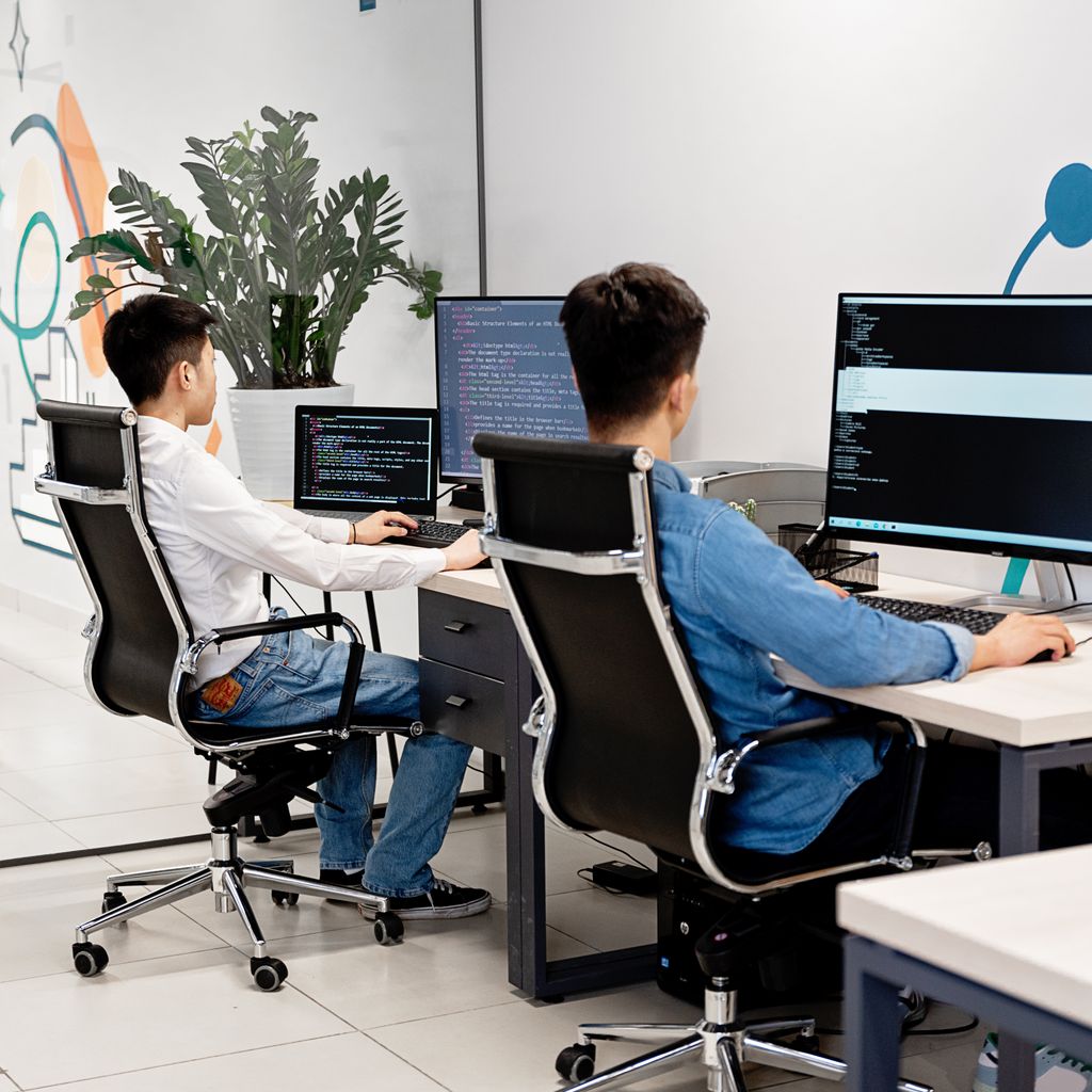Two developers working at their desks in a bright office