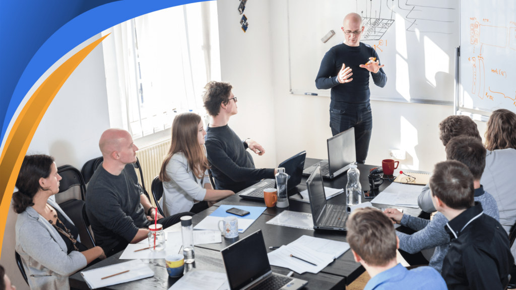 Sales manager leading a training session with a team around a meeting table