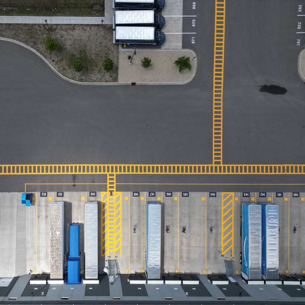 Aerial view of numbered dock doors at a distribution yard with trailers backed in