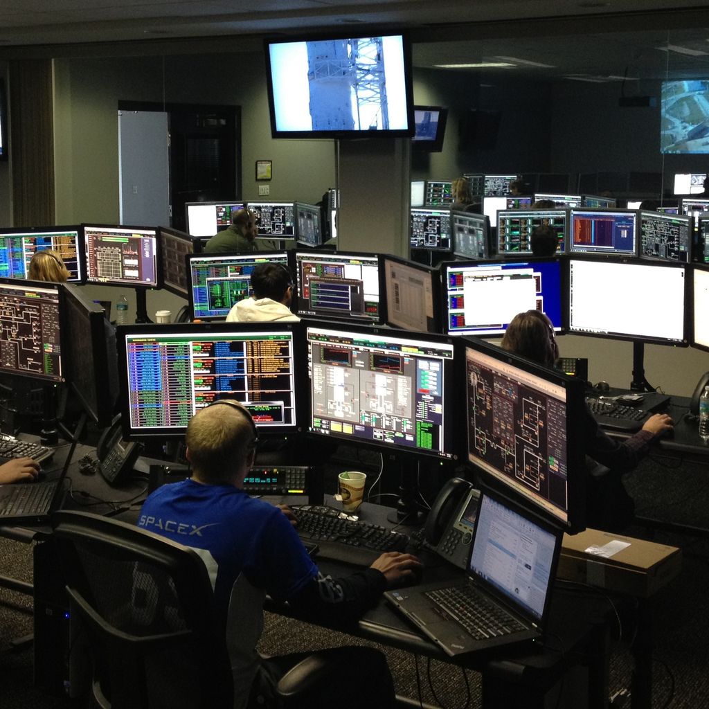 Engineers working at desks with many monitoring screens