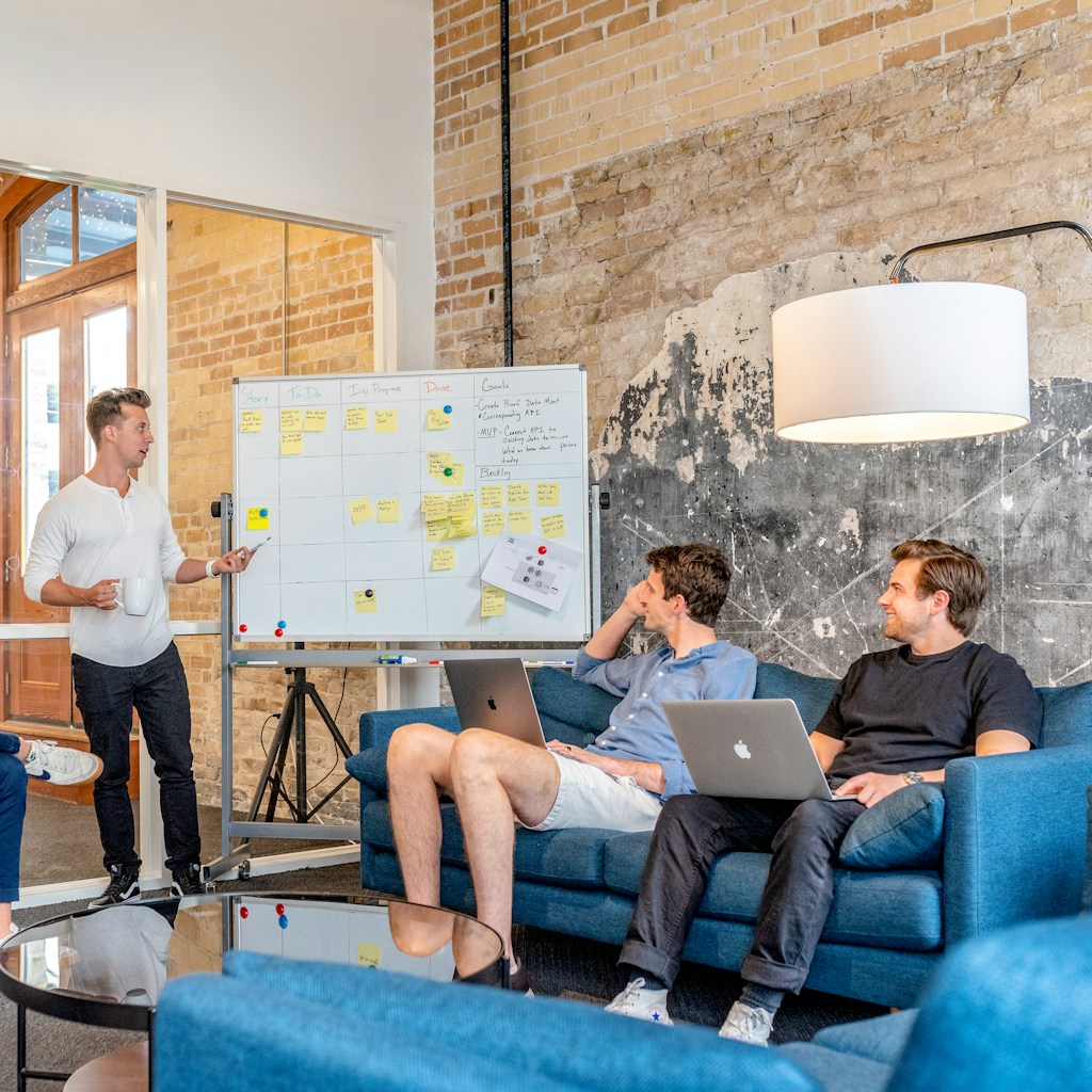 A team planning a project around a board of sticky notes
